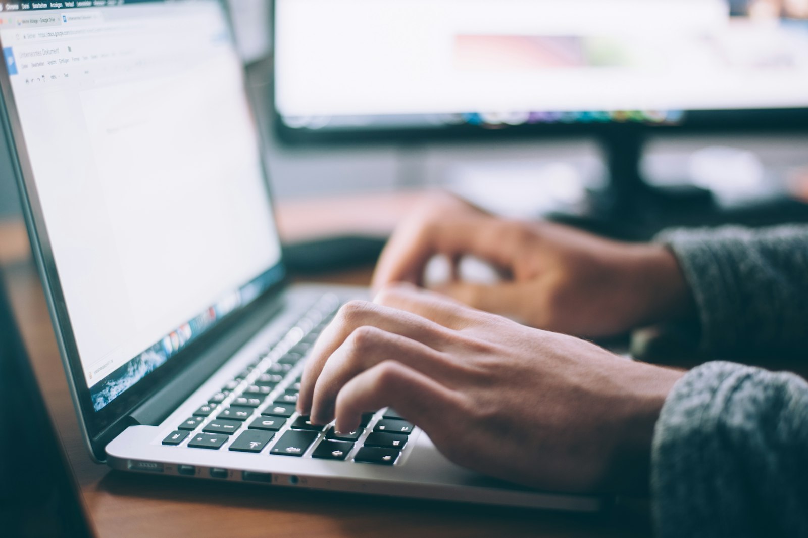 Hands typing on a laptop keyboard in warm daylight — everyday office work made faster with Microsoft 365 automation.